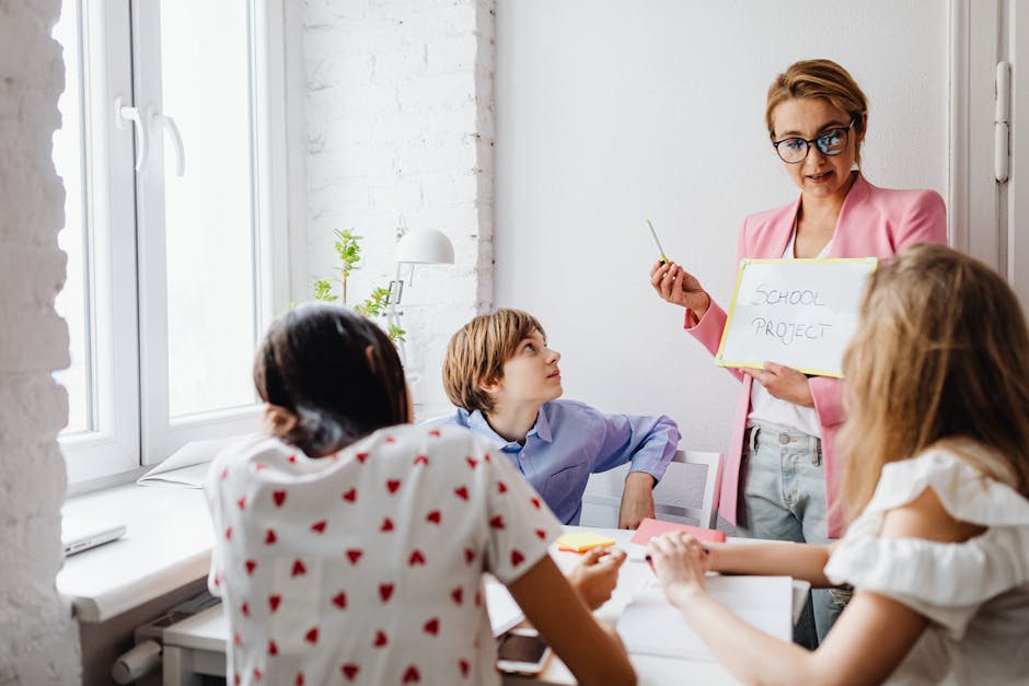 A teacher engaging with students in a classroom setting for a school project discussion